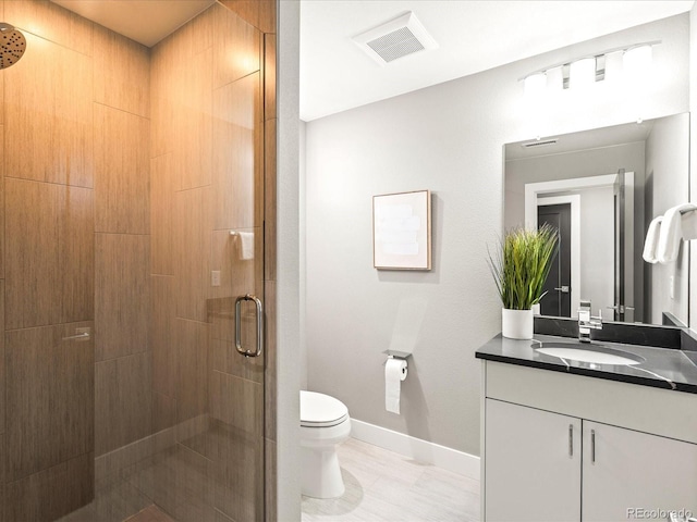 bathroom with toilet, vanity, visible vents, baseboards, and a shower stall