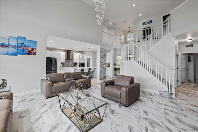 12404 Pine Valley Cir, Peyton, CO 80831 - living room featuring a high ceiling, stairway, recessed lighting, light marble finish flooring, and a chandelier