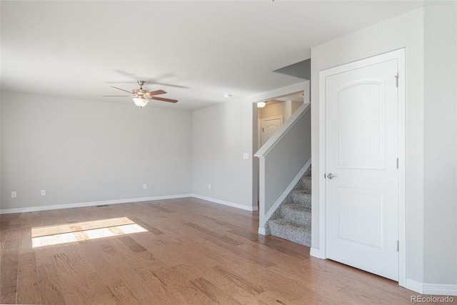 empty room with ceiling fan and light hardwood / wood-style flooring