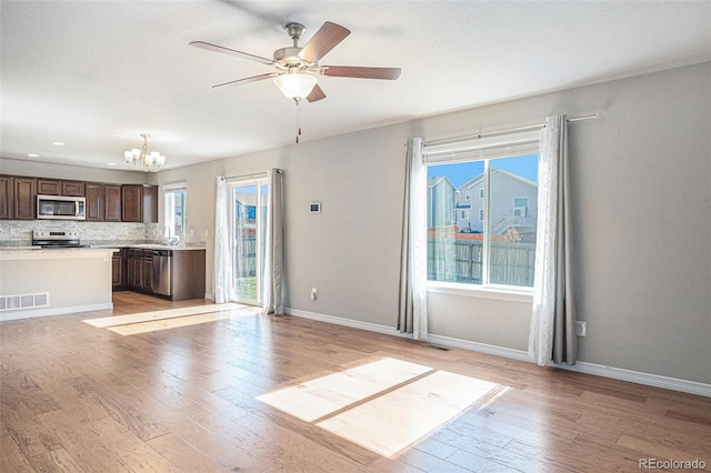 kitchen with plenty of natural light, dark brown cabinetry, backsplash, and appliances with stainless steel finishes