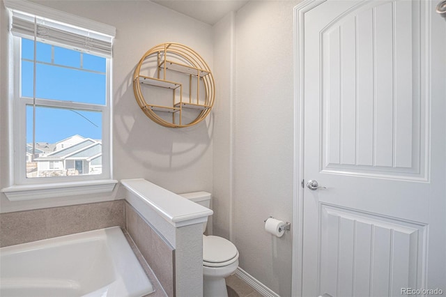 bathroom featuring a washtub and toilet