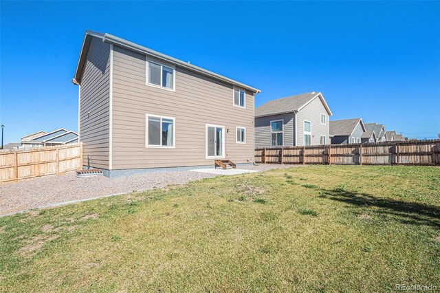 back of house with a lawn and a patio area