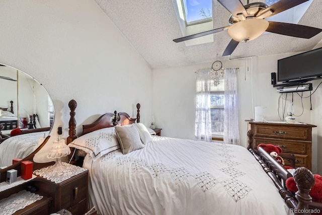 bedroom with ceiling fan, a textured ceiling, and lofted ceiling with skylight