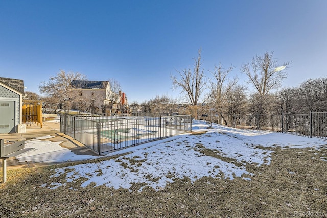 yard covered in snow with a covered pool and a patio