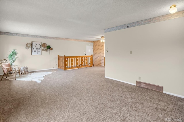 unfurnished room featuring ceiling fan, carpet floors, and a textured ceiling