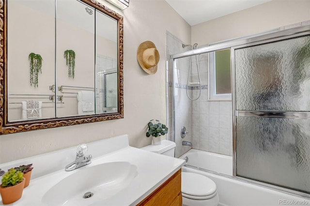 full bathroom featuring vanity, bath / shower combo with glass door, and toilet