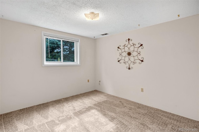 carpeted spare room with a textured ceiling