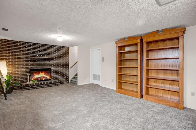 unfurnished living room with carpet flooring, a fireplace, and a textured ceiling