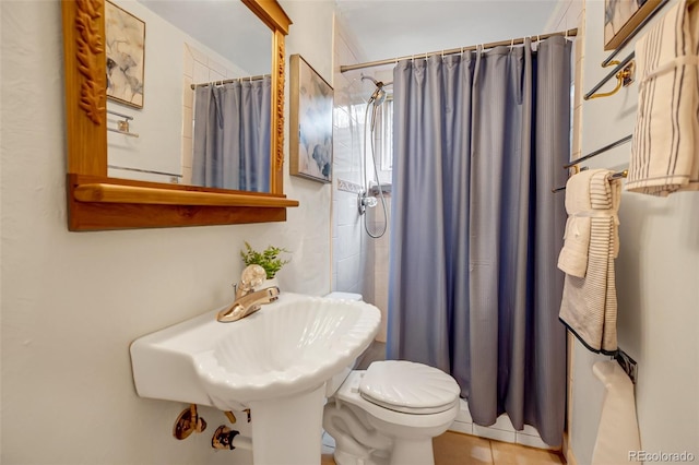 bathroom with tile patterned flooring, walk in shower, and toilet