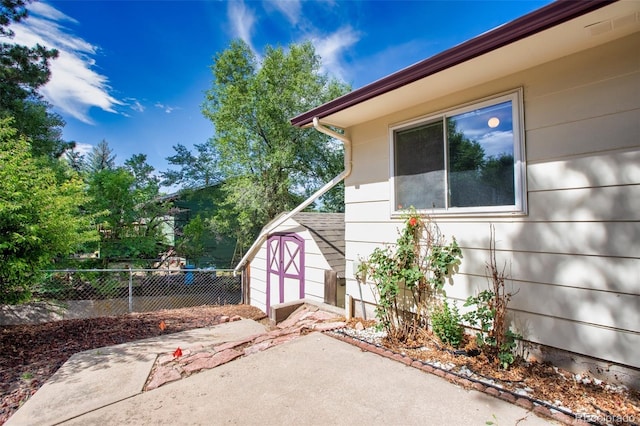 view of home's exterior with a storage shed and a patio area