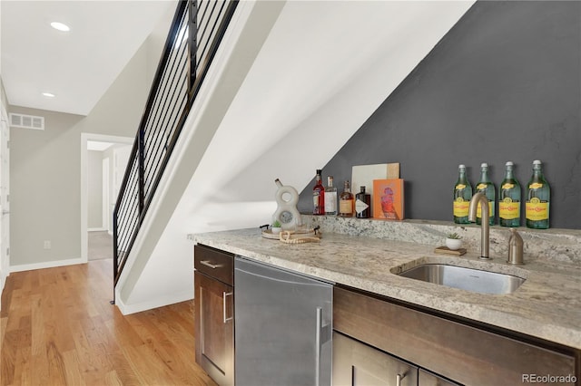 bar featuring visible vents, light wood-style flooring, a sink, stairway, and wet bar