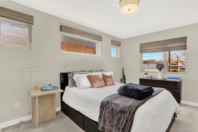 bedroom featuring baseboards and light colored carpet