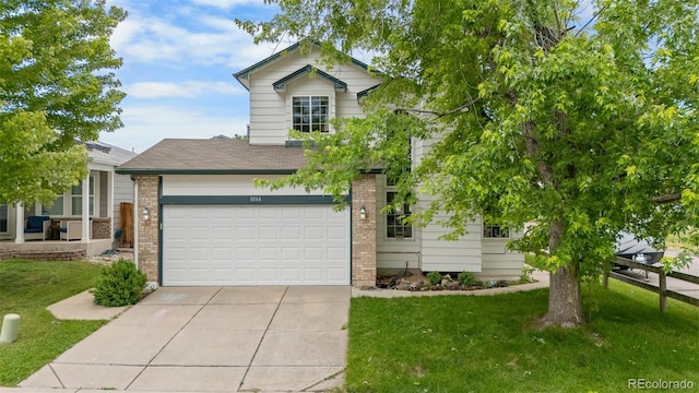 8544 S Upham Way, Littleton, CO 80128 - view of front facade featuring driveway, brick siding, a front yard, and roof with shingles