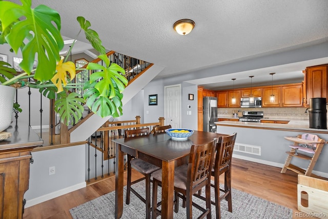 8544 S Upham Way, Littleton, CO 80128 - dining room with wood finished floors, stairway, and a textured ceiling