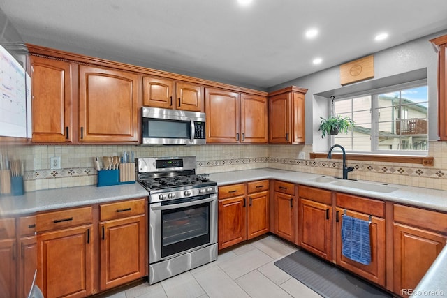8544 S Upham Way, Littleton, CO 80128 - kitchen with stainless steel appliances, light countertops, decorative backsplash, brown cabinets, and recessed lighting