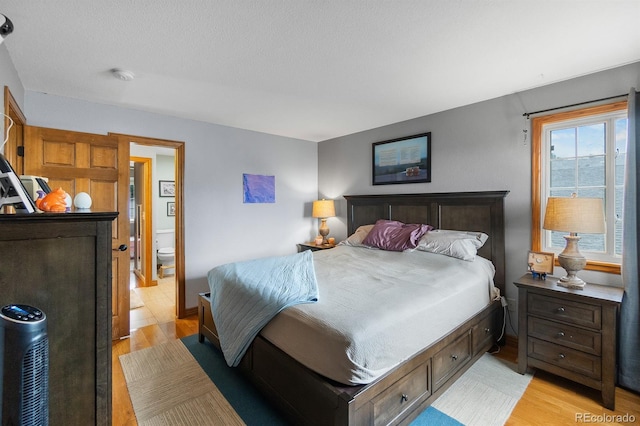 8544 S Upham Way, Littleton, CO 80128 - bedroom with light wood-style floors and ensuite bath