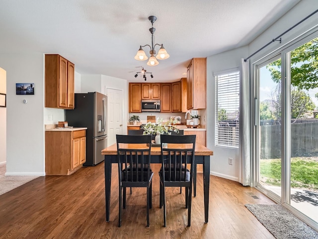 dining room featuring a chandelier, baseboards, and wood finished floors