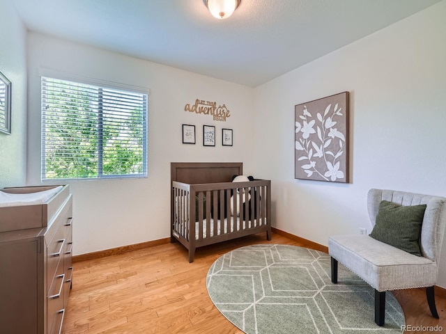 bedroom with light wood-type flooring and baseboards