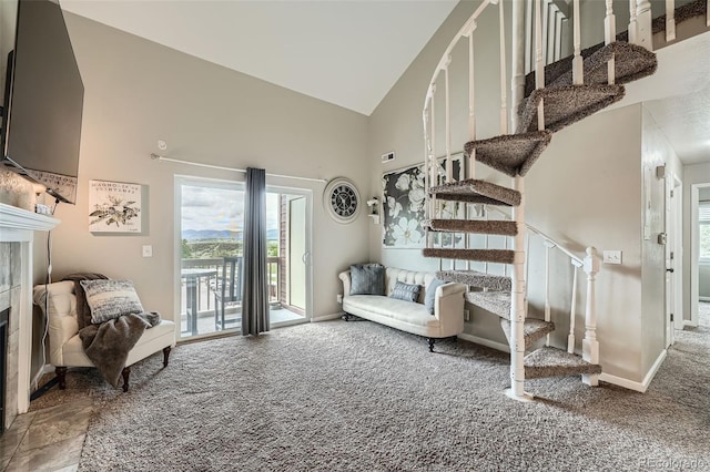 10872 W Evans Ave Unit 3D, Lakewood, CO 80227 - living room featuring a tiled fireplace, high vaulted ceiling, carpet flooring, stairs, and healthy amount of natural light