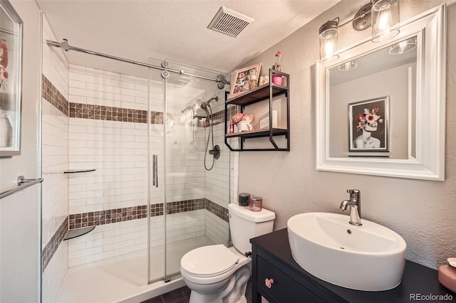 10872 W Evans Ave Unit 3D, Lakewood, CO 80227 - bathroom featuring a shower stall, toilet, vanity, a textured wall, and a textured ceiling