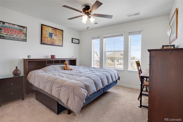 bedroom featuring light colored carpet, baseboards, and a ceiling fan