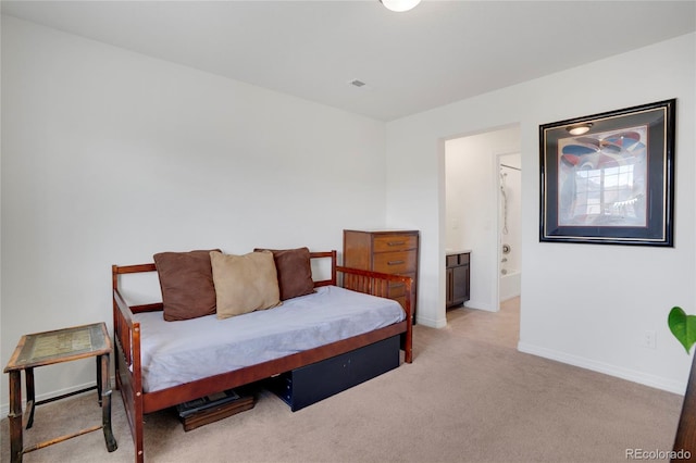 bedroom with light carpet, baseboards, and ensuite bath