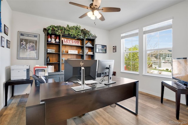 home office with a ceiling fan, wood finished floors, and baseboards