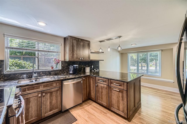 6338 S Oneida Ct, Centennial, CO 80111 - kitchen featuring stainless steel appliances, a sink, light wood-type flooring, a peninsula, and dark stone countertops