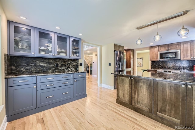 6338 S Oneida Ct, Centennial, CO 80111 - kitchen featuring stainless steel appliances, decorative backsplash, light wood-type flooring, dark stone counters, and recessed lighting