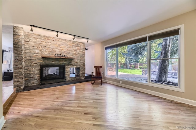 6338 S Oneida Ct, Centennial, CO 80111 - unfurnished living room featuring rail lighting, wood finished floors, baseboards, and a fireplace