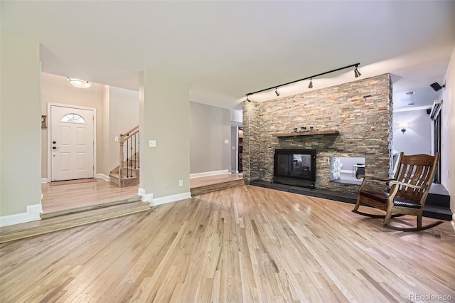 6338 S Oneida Ct, Centennial, CO 80111 - unfurnished living room with rail lighting, wood finished floors, stairs, and a fireplace