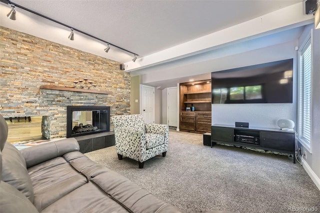 6338 S Oneida Ct, Centennial, CO 80111 - carpeted living room with track lighting, a stone fireplace, and baseboards