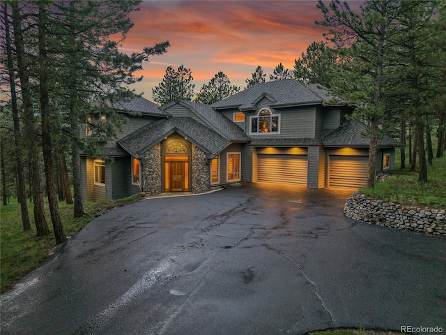 29433 Firethorne Ct, Evergreen, CO 80439 - view of front of house with driveway, stone siding, and a shingled roof
