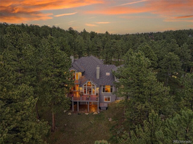 29433 Firethorne Ct, Evergreen, CO 80439 - back of property with a chimney, a view of trees, a deck, and stairway