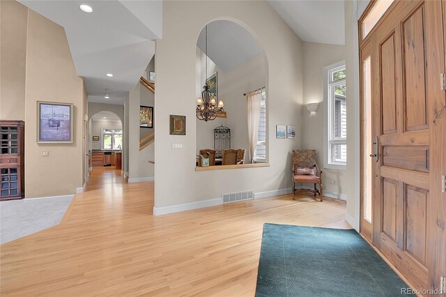 29433 Firethorne Ct, Evergreen, CO 80439 - foyer entrance with arched walkways, light wood-type flooring, healthy amount of natural light, high vaulted ceiling, and baseboards