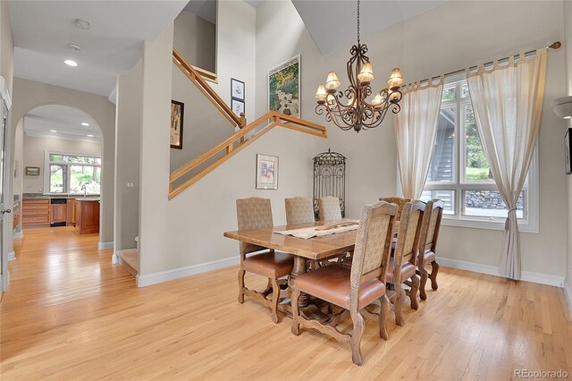 29433 Firethorne Ct, Evergreen, CO 80439 - dining room with arched walkways, light wood finished floors, baseboards, stairway, and a chandelier