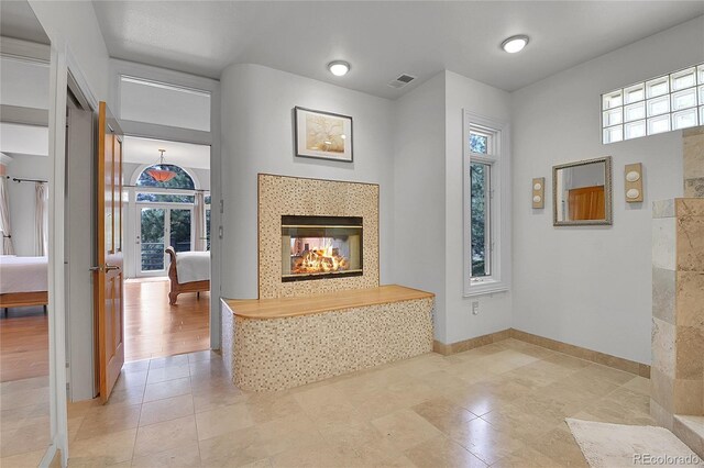29433 Firethorne Ct, Evergreen, CO 80439 - unfurnished living room featuring plenty of natural light, baseboards, a fireplace, and tile patterned flooring