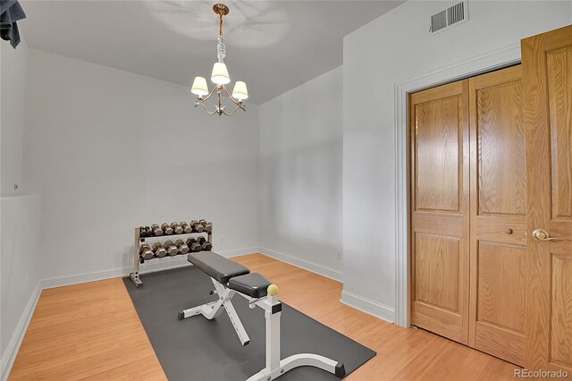29433 Firethorne Ct, Evergreen, CO 80439 - exercise area with a chandelier, light wood-type flooring, and baseboards