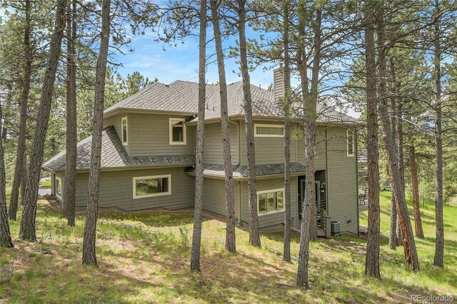 29433 Firethorne Ct, Evergreen, CO 80439 - back of property featuring a chimney, central air condition unit, and roof with shingles