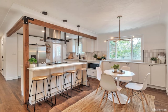 2598 Teller St, Lakewood, CO 80214 - kitchen featuring stainless steel appliances, white cabinetry, dark wood finished floors, and decorative backsplash