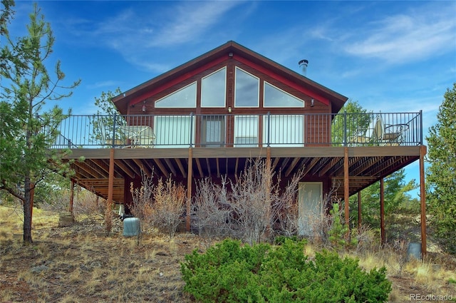 rear view of house featuring a wooden deck