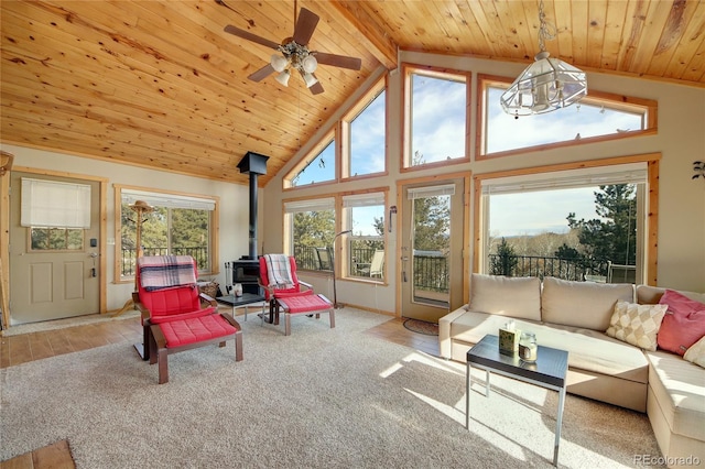 sunroom with vaulted ceiling with beams, a wood stove, and a wealth of natural light