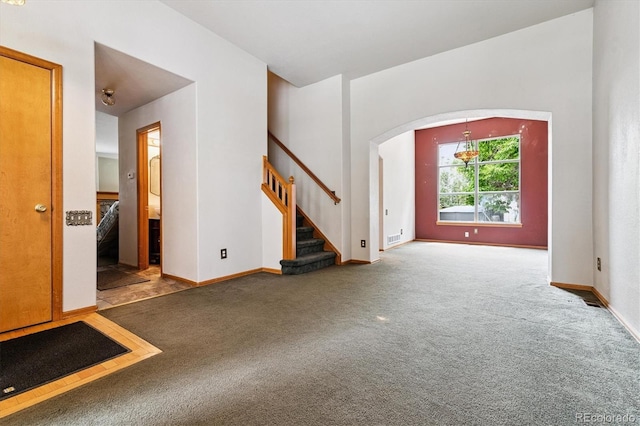 2780 S Cathay Ct, Aurora, CO 80013 - unfurnished living room featuring carpet flooring, arched walkways, and stairway
