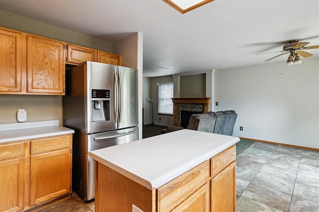 2780 S Cathay Ct, Aurora, CO 80013 - kitchen featuring stainless steel fridge, a ceiling fan, a stone fireplace, light countertops, and a center island