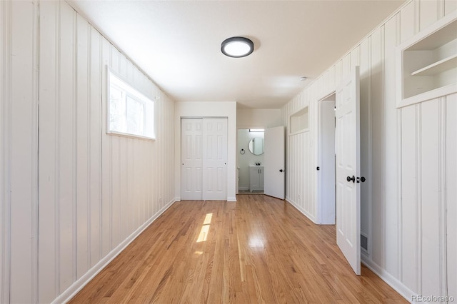 hall with baseboards and light wood-style floors