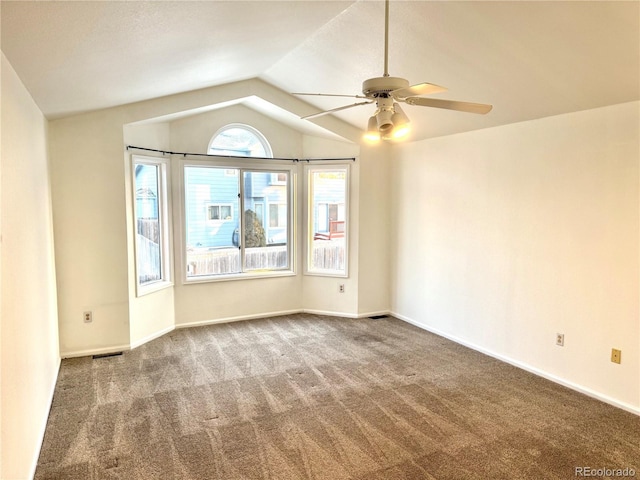 empty room featuring carpet floors, vaulted ceiling, and ceiling fan