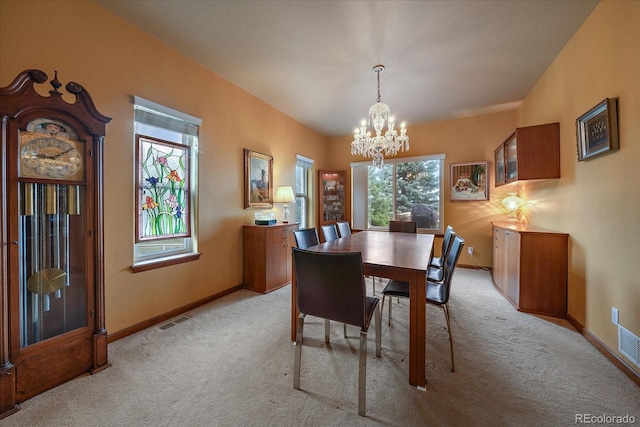 carpeted dining area featuring a chandelier