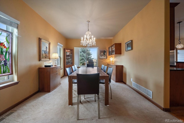 dining space featuring a chandelier and light colored carpet