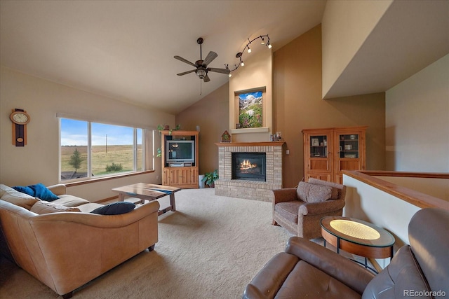 carpeted living room featuring high vaulted ceiling, a fireplace, track lighting, and ceiling fan