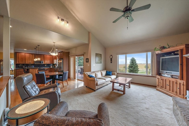 living room with ceiling fan, vaulted ceiling, and light colored carpet